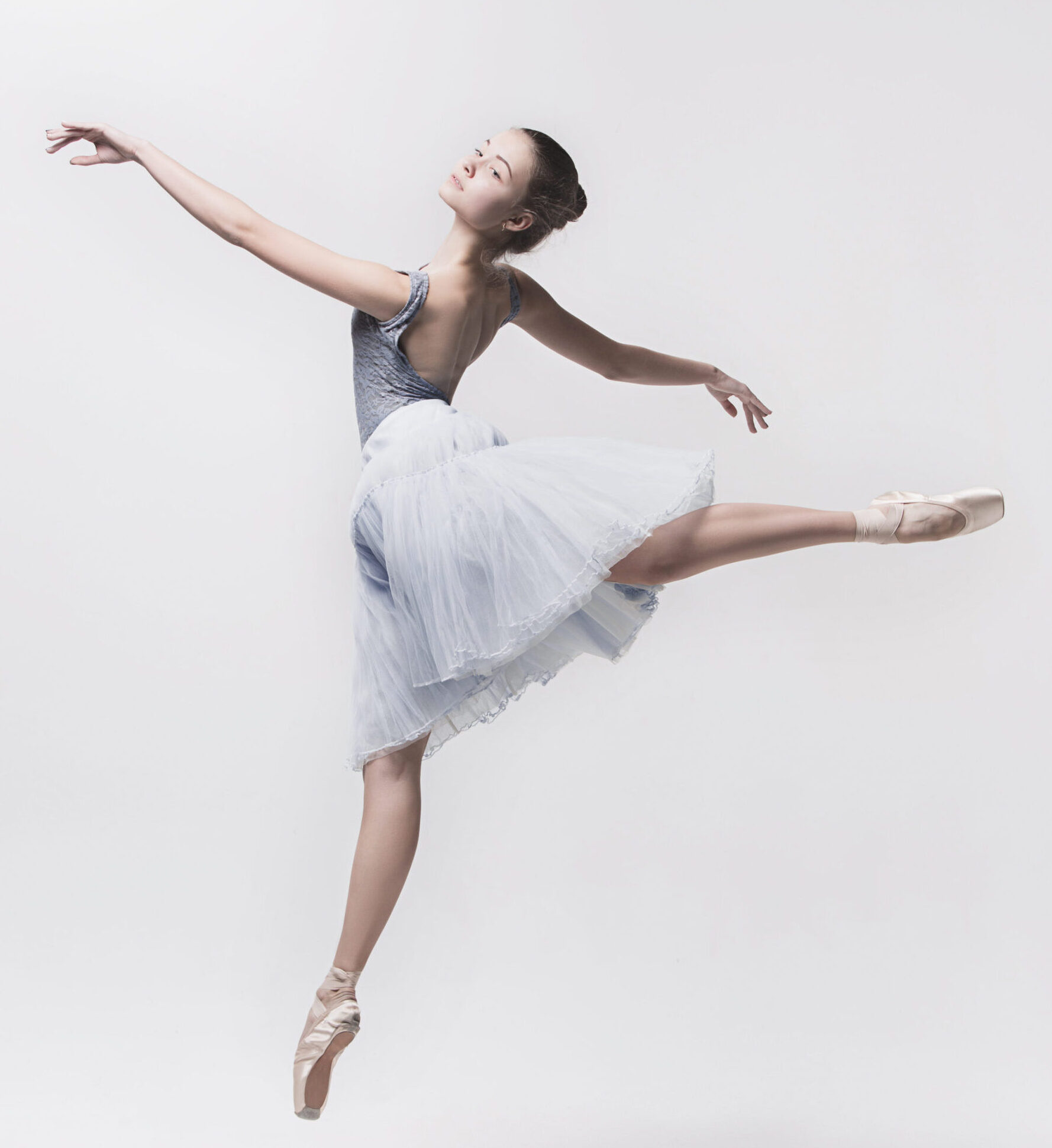 Young classical dancer dancing on white background. Ballerina project.